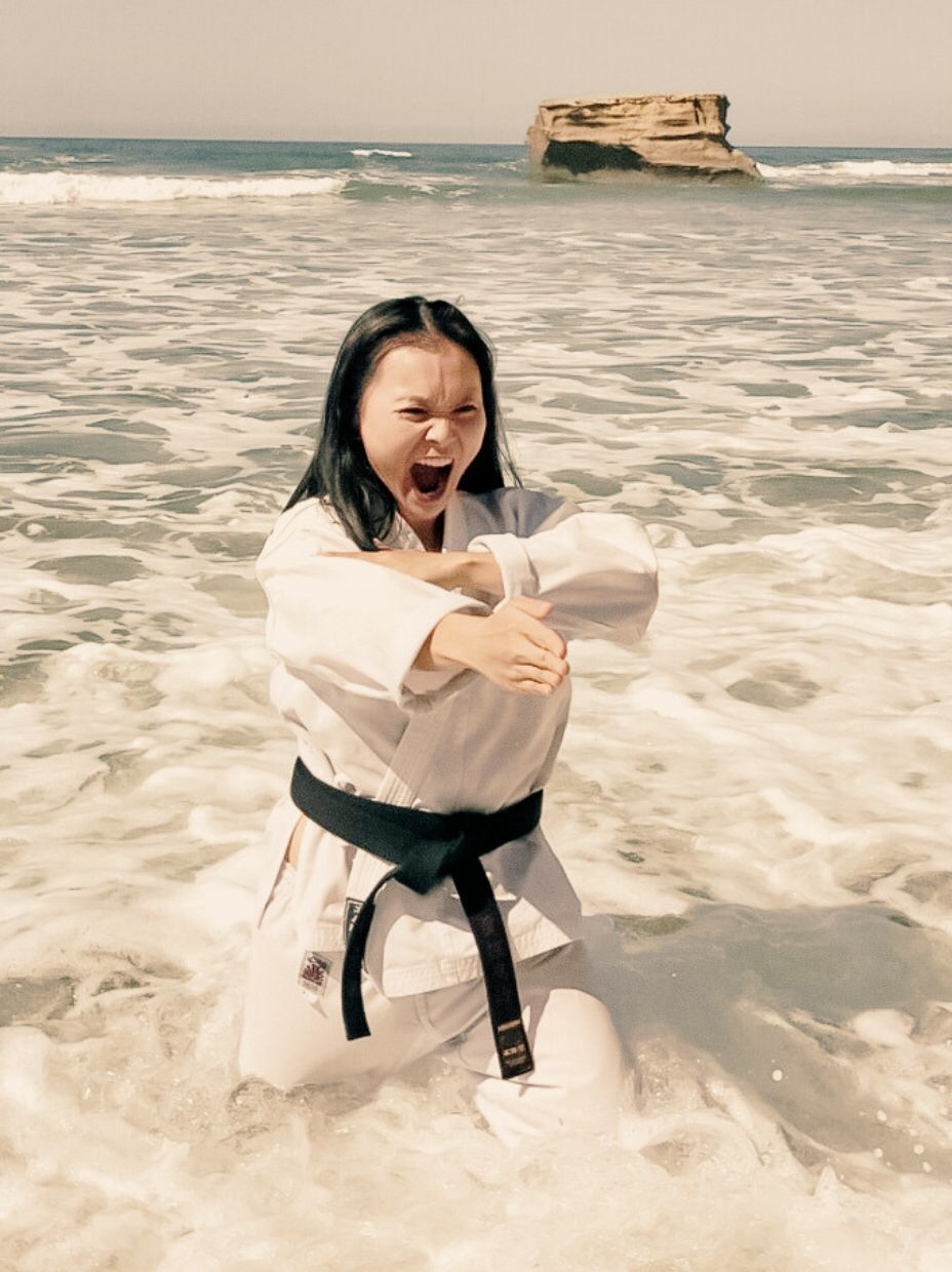Sheryn Gung performing a spear-hand strike from Traditional Gōjū Karate at Jan Juc Surf Beach, Surf Coast. You can see Bird Rock behind her.